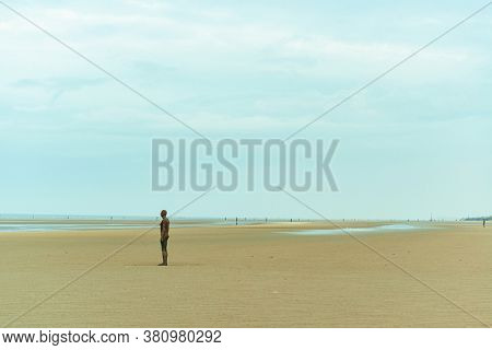 LIVERPOOL, UK - FEB 23, 2020: Antony Gormley's Another Place artwork on beach in England in United Kingdom