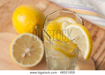 Citronový nápoj ve sklenici a citrony