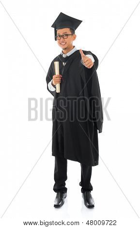 Zachycovací asijské mužské univerzitní student v maturitní šaty palec nahoru izolované na bílém pozadí