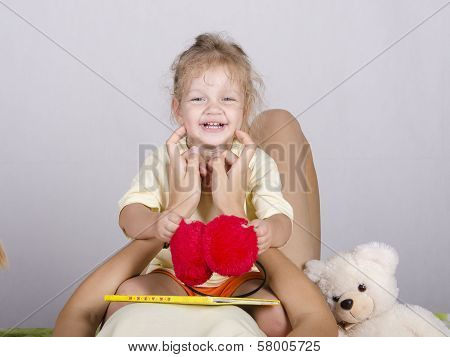 Little Girl Sitting On Mom And Laughs
