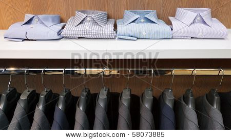 Row Of Men Suit Jackets On Hangers And Shelf With Shirt