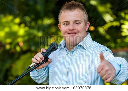 Handicapped Boy With Microphone Doing Thumbs Up.