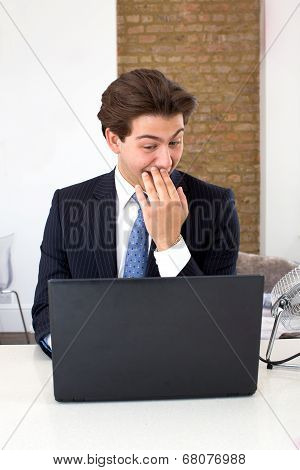 Businessman Reading His Laptop With A Snigger
