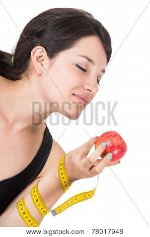 closeup portratit beautiful young girl holding a red apple and measuring tape