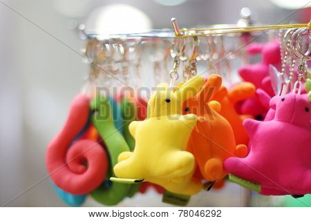Small Soft Multicolored Bunnies And Snakes Keychains Hang In Shop. Shallow Dof