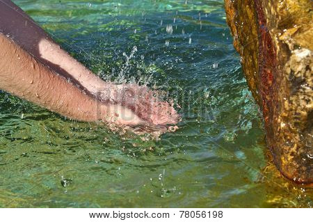 Beautiful woman hand in clear mountain water