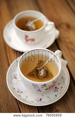 Two Cups Of Green Tea In Triangle Bagks