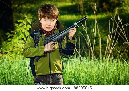 A boy playing with a toy rifle outdoor. Military concept. Childhood.