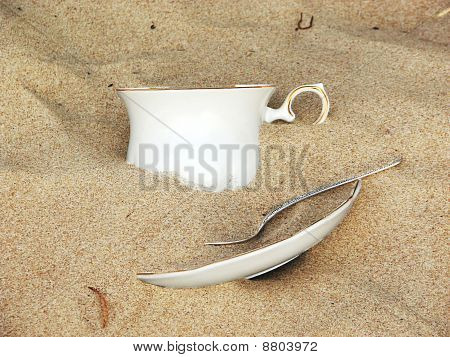 Tasse und Untertasse gefüllt von Sand