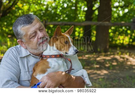 Portrait of a bearded senior man with his basenji dog