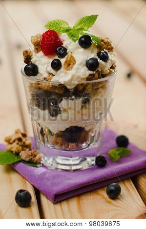 Sweet Fresh Cottage-cheese And Granola Dessert Topped With Blueberries, Raspberry And A Mint Leaf