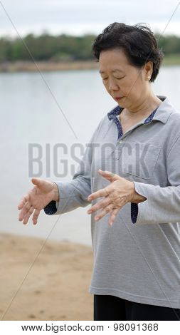 Asian Senior Elderly Practice Taichi, Qi Gong Exercise Next To The Lake