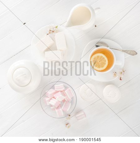 Nice tea ceremony with zefir and marshmellow, lemon with tea and sweets, topview