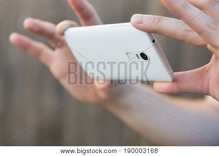 A Man Takes Pictures Or Shoots Video On A Smartphone. Close-up Of Hand And Gadget In A Horizontal Po