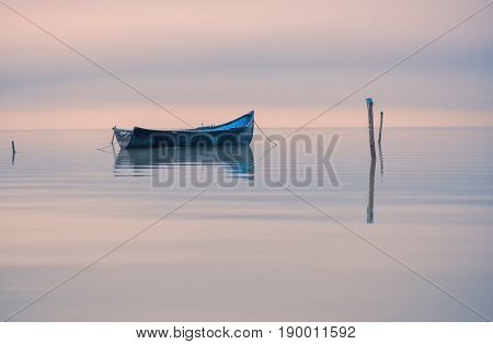 Old rowboat on the lake at sunset
