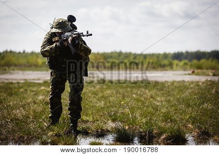 Photo of military man with gun in field during day