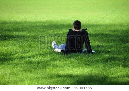 Young man relaxing on the grassy field