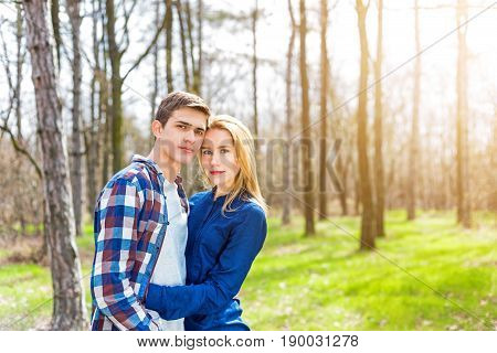 Close up portrait of attractive girl embracing her boyfriend outdoors.