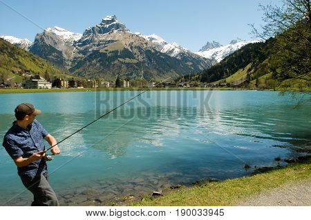 Fisherman Fishing On The Lake At The Village Of Engelberg