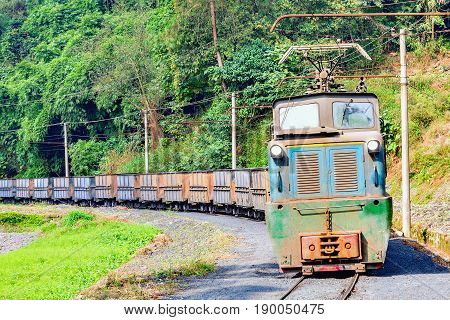 Electric narrow-gauge locomotive with the empty freight train moves from Shixi to Yuejin. Jiayang Mining Region. Sichuan province. China.