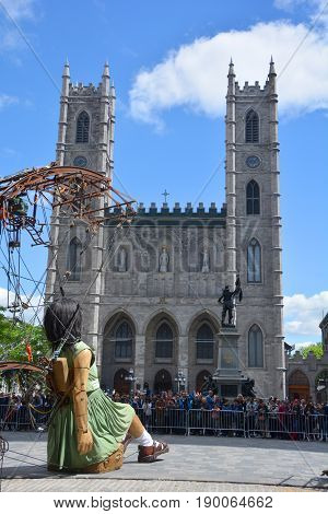 MONTREAL QUEBEC CANADA 19 05 17: The little giant girl sleeping in Place d'arme in old Montreal for the 375e anniversary of the city, by Royal De Luxe company Nantes France