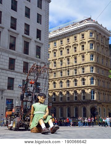 MONTREAL QUEBEC CANADA 19 05 17: The little giant girl sleeping in Place d'arme in old Montreal for the 375e anniversary of the city, by Royal De Luxe company Nantes France