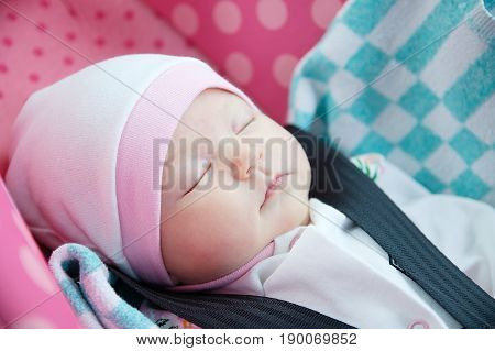 Newborn sleeping in car seat.Safety concept. Infant baby girl. secure driving with children. Baby care lifestyle. Cute baby sleeping in car.