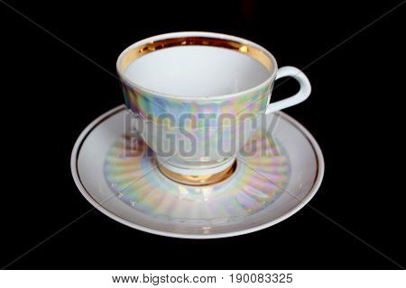 A white iridescent tea cup and saucer