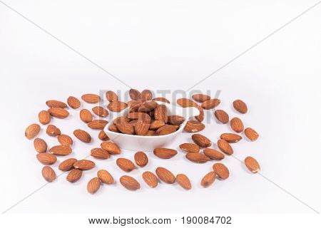 Delicious almond nuts in white bowl on white background
