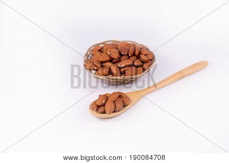 Delicious almond nuts in wooden spoon  and the basketon white background