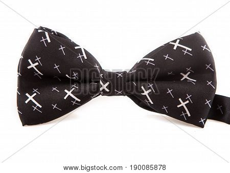 Glamorous elegant accessory bow tie black with white crosses on isolated white background, close-up.