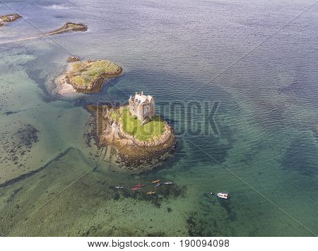 Aerial canoes gathering around the historic castle Stalker in Argyll, Scotland