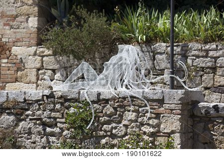 BAGNO VIGNONI, ITALY - JUNE 3 2017: Riflessi sculpture by Daniela Capaccioli in the medieal town of Bagno Vignoni in Tuscany Italy transparent metal wires sculptures