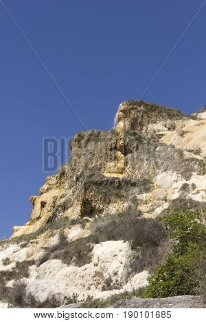 BAGNO VIGNONI, ITALY - JUNE 3 2017: Natural Hot springof Bagno Vignoni in Italy with its small cascade through nature