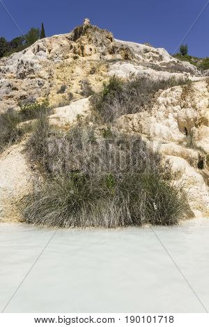 BAGNO VIGNONI, ITALY - JUNE 3 2017: Hot springs thermal pool of Bagno Vignoni in Tuscany with the mount from where the water springs. Tuscany.