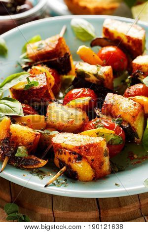 Vegetarian, grilled skewers of halloumi cheese and vegetables with addition aromatic herbs