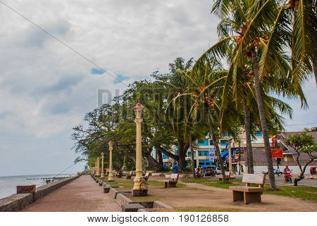 Waterfront with beautiful trees in cloudy weather. Dumaguete City, Philippines