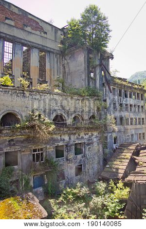 Abandoned overgrown ruins of destroyed by war Tkvarcheli (Tquarhcal) power plant, Abkhazia, Georgia