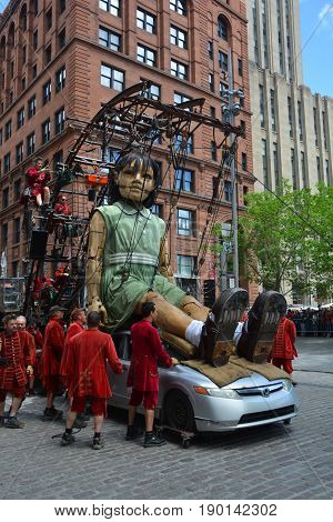 MONTREAL QUEBEC CANADA 19 05 17: The little giant girl walking in the street of Montreal for the 375e anniversary of the city, by Royal De Luxe company Nantes France