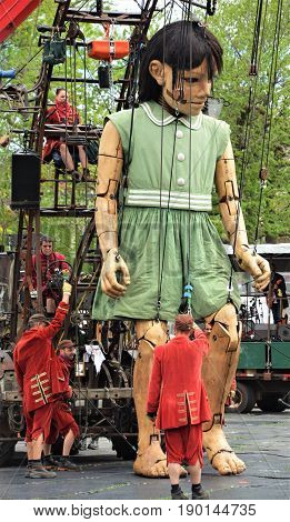 MONTREAL QUEBEC CANADA 19 05 17: The little giant girl walking in the street of Montreal for the 375e anniversary of the city, by Royal De Luxe company Nantes France