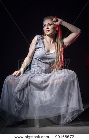 Actress In A Grey Dress On A Dark Stage