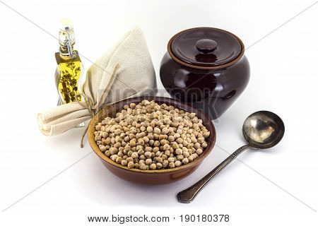 The Composition Of Chick Peas In A Clay Pial Next To A Clay Pot And A Copper Spoon,