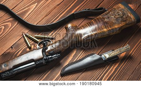 Hunting equipment on old wooden background and bullets.