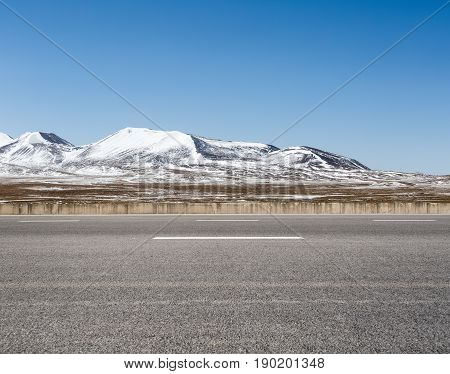 empty asphalt road on snow area plateau tibet
