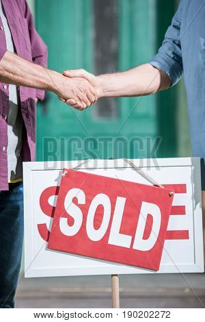 Cropped View Of Men Shaking Hands With Saleman And Buying New House