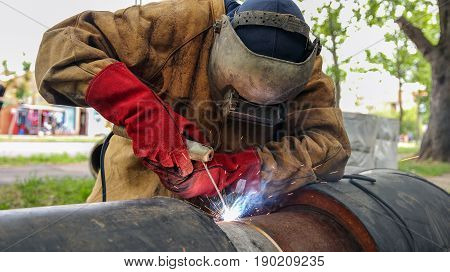 Welder With Protective Equipment Welding Outdoors.
Pipe welding on the pipeline construction.