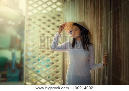 Beautiful woman wearing hat in white Ao dai Vietnam Traditional dress of Dress culture Vietnamese