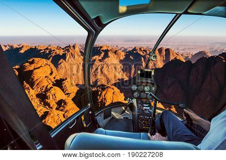 Helicopter cockpit flight aerial view of the holy summit of Mount Sinai, Aka Jebel Musa, 2285 meters, at sunrise, Sinai Peninsula in Egypt. Spirituality, religion and history concept.