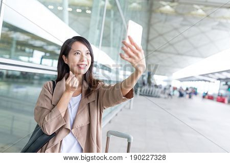 Woman taking selfie and posing korean haert gesture