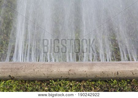 water leaking from hole in a hose.